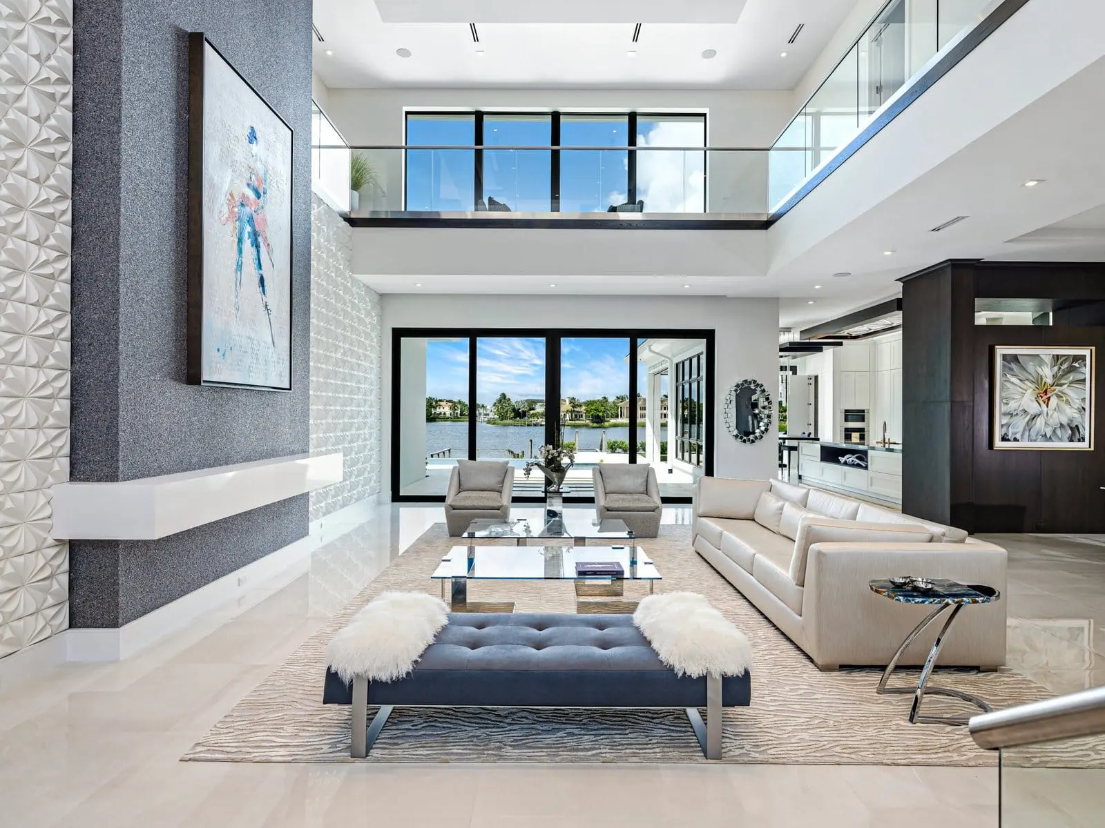 Palm Beach luxury living room with two-story windows, waterfront view, and modern neutral furnishings.