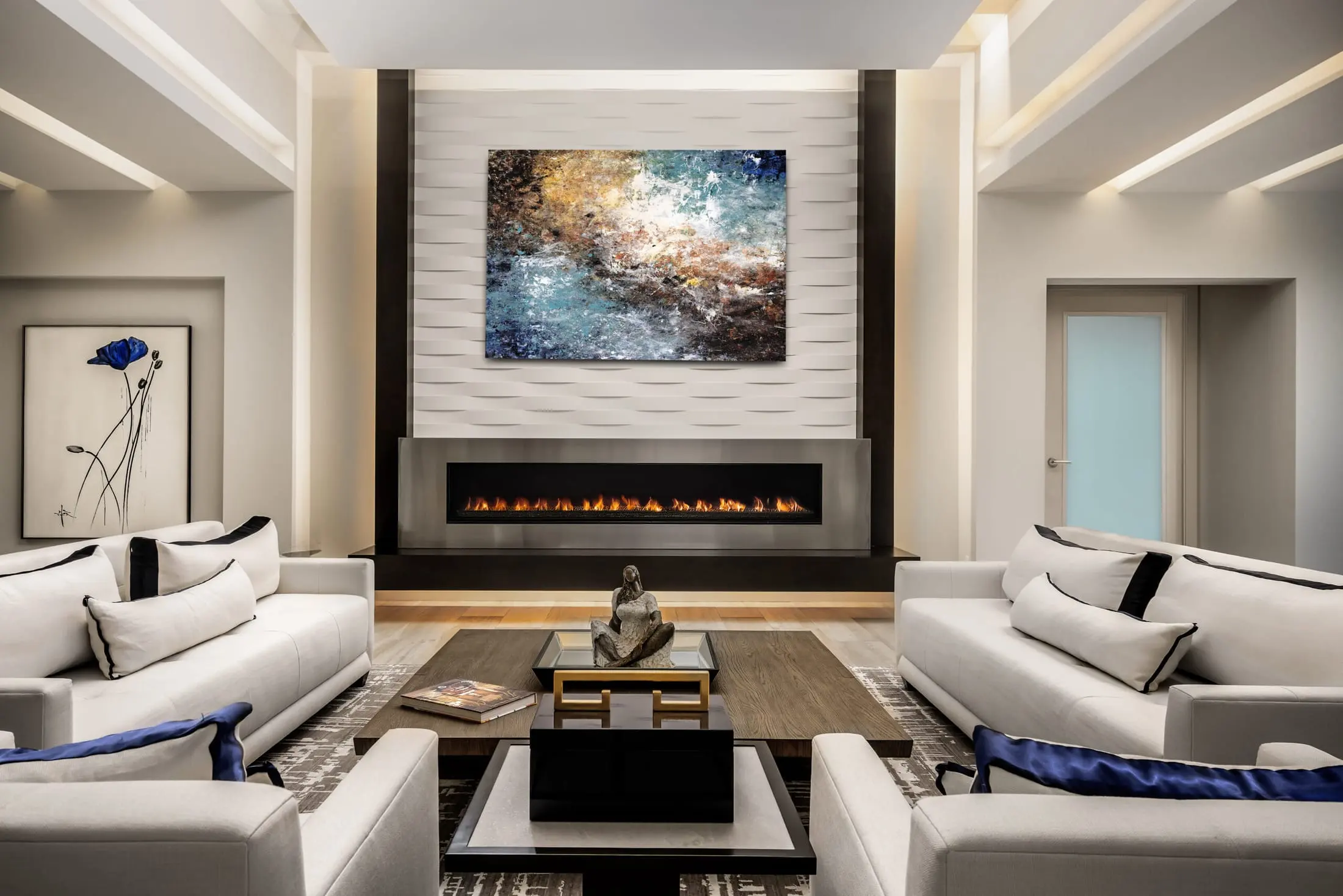 Contemporary living room in an Admirals Cove home in Jupiter featuring a modern linear fireplace, textured feature wall, abstract art, and white sofas with bold accents.