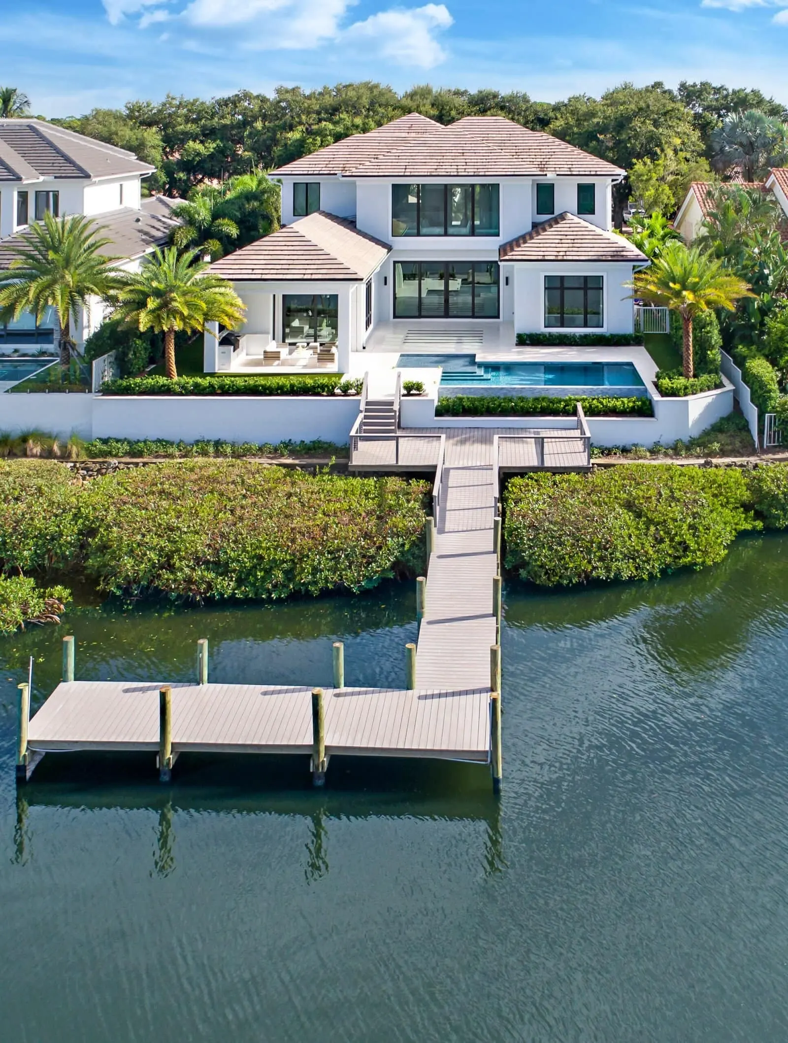 Palm Beach modern waterfront home with boat dock, elevated pool deck, and contemporary coastal architecture.