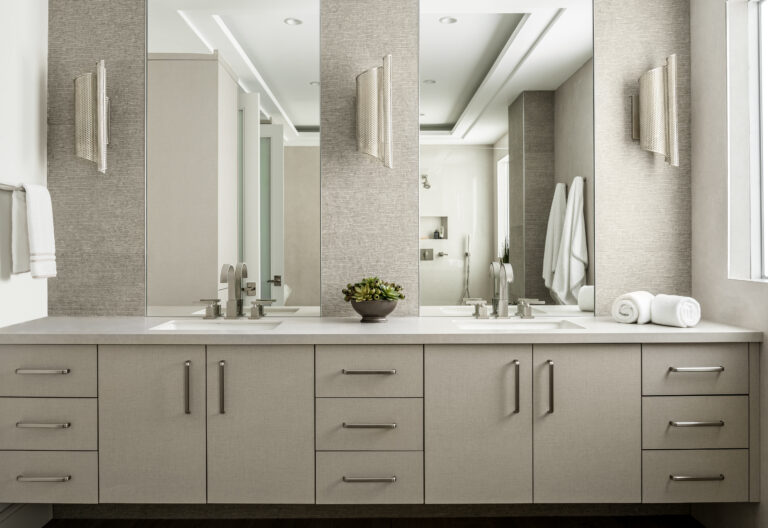 Modern double vanity bathroom with textured wall panels, sleek fixtures, and neutral tones by Integrative Designs Inc.