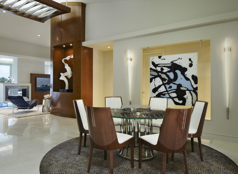 Contemporary dining room with glass table, sculptural wood accents, and abstract wall art by Integrative Designs Inc.